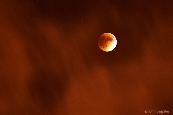 Supermoon Eclipse Under a Veil of Clouds